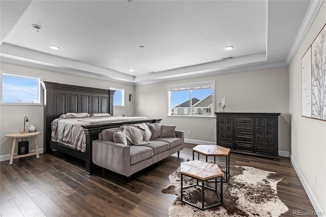 bedroom featuring dark wood-type flooring, a tray ceiling, and ornamental molding