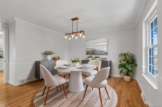 dining room with light hardwood / wood-style floors and ornamental molding