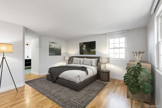 bedroom with connected bathroom and wood-type flooring