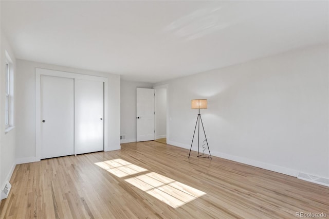 unfurnished bedroom with a closet and light wood-type flooring