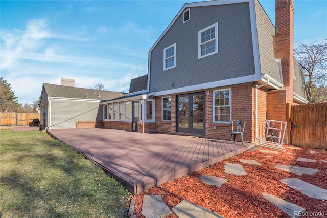 rear view of property with a lawn and french doors