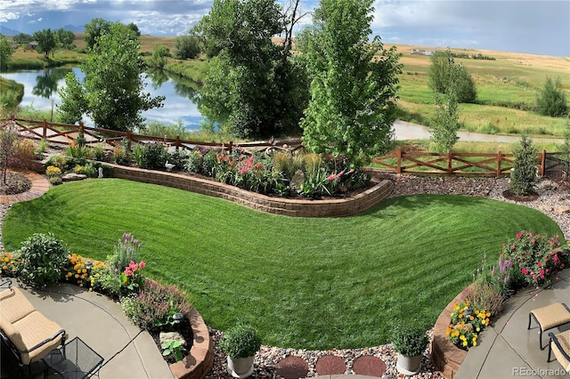 view of yard featuring fence and a water view