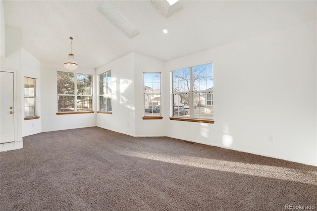 unfurnished room with lofted ceiling with skylight, visible vents, and carpet flooring