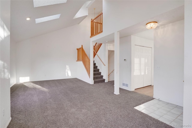 unfurnished living room featuring high vaulted ceiling, stairway, visible vents, and light colored carpet