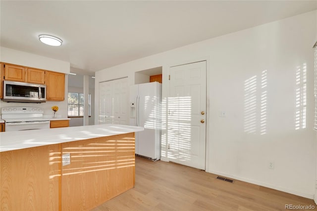 kitchen featuring white appliances, visible vents, baseboards, light countertops, and light wood-type flooring