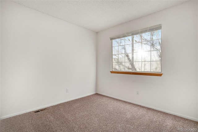 unfurnished room with baseboards, a textured ceiling, visible vents, and carpet flooring