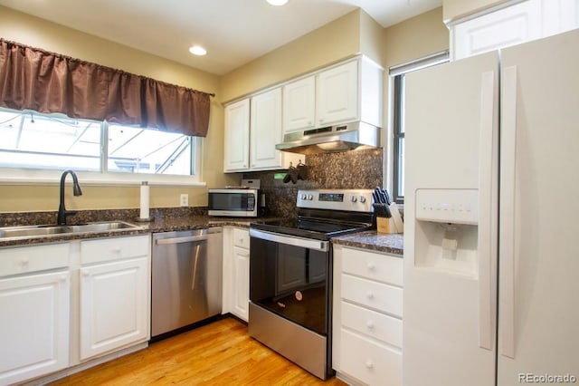 10652 W Florida Ave Unit D, Lakewood, CO 80232 - kitchen featuring appliances with stainless steel finishes, under cabinet range hood, white cabinets, decorative backsplash, and recessed lighting
