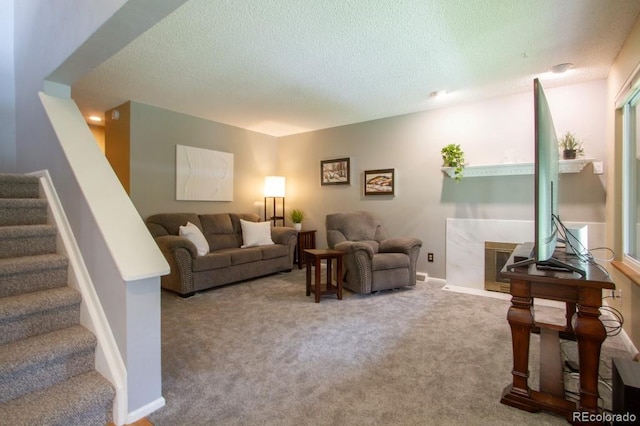 10652 W Florida Ave Unit D, Lakewood, CO 80232 - living area featuring stairs, a textured ceiling, a fireplace, and carpet floors