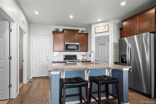 119 Jackson Dr, Erie, CO 80516 - kitchen featuring tasteful backsplash, a sink, stainless steel appliances, dark wood-type flooring, and visible vents