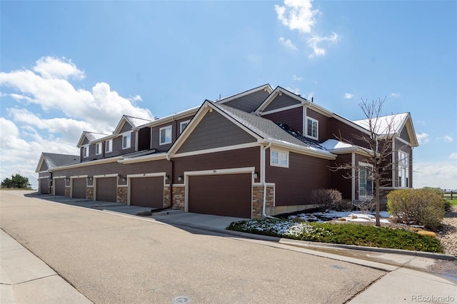 119 Jackson Dr, Erie, CO 80516 - view of front of property featuring a garage, driveway, and stone siding