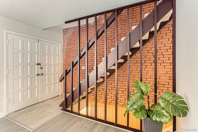 stairs with hardwood / wood-style floors and a textured ceiling