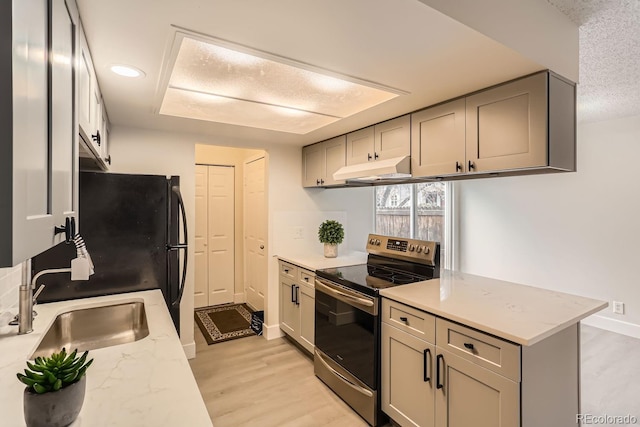 kitchen featuring gray cabinetry, light wood-type flooring, electric stove, and light stone counters