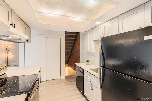 kitchen with light hardwood / wood-style flooring, white cabinetry, and black appliances