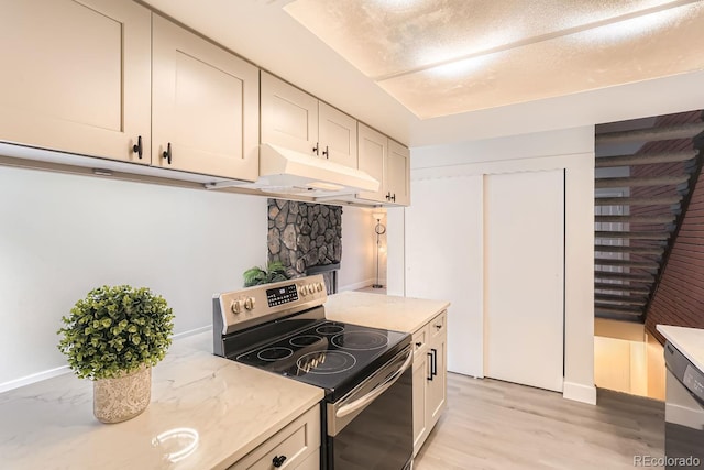 kitchen featuring light stone counters, appliances with stainless steel finishes, and light hardwood / wood-style flooring