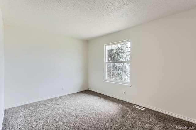 carpeted spare room featuring a textured ceiling