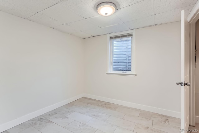 unfurnished room featuring a drop ceiling