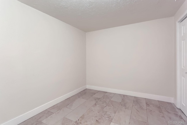 unfurnished room featuring a textured ceiling