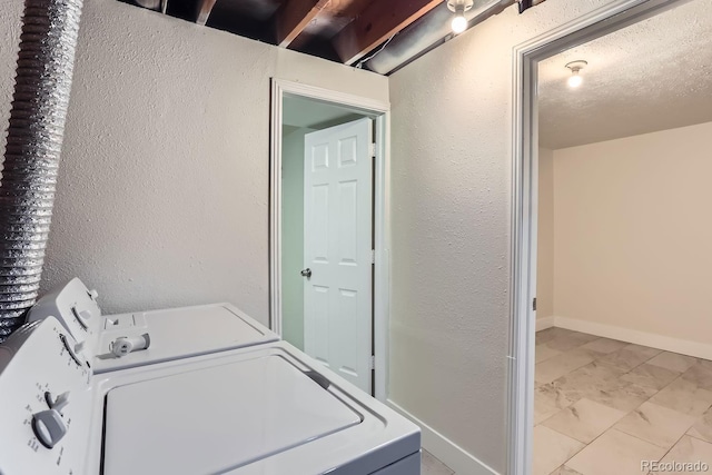 clothes washing area featuring a textured ceiling and washing machine and clothes dryer