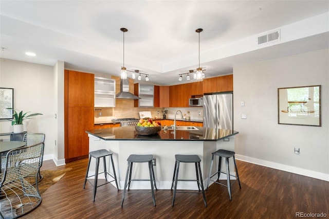 2240 N Clay St Unit 309, Denver, CO 80211 - kitchen featuring appliances with stainless steel finishes, brown cabinets, wall chimney exhaust hood, modern cabinets, and a kitchen breakfast bar