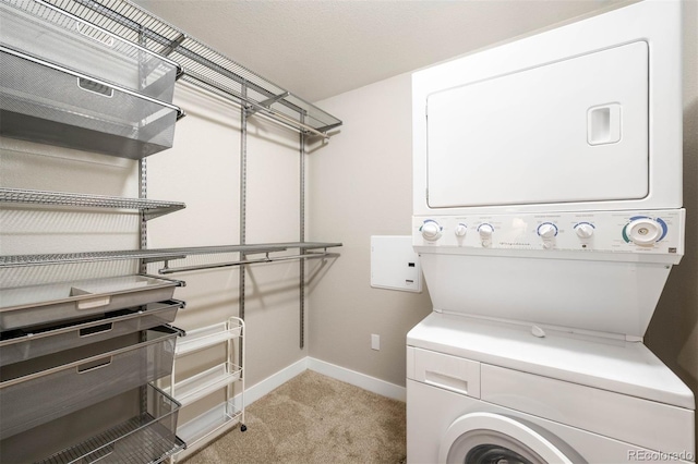 2240 N Clay St Unit 309, Denver, CO 80211 - washroom with stacked washer / dryer and light carpet