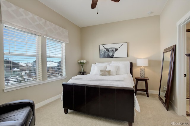 bedroom with light carpet, ceiling fan, and baseboards