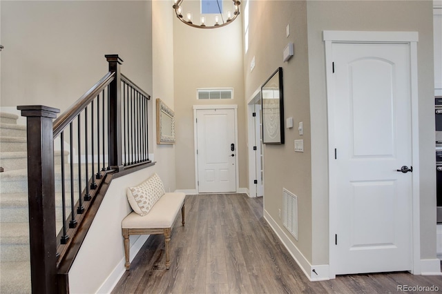 entrance foyer featuring stairs, visible vents, and wood finished floors