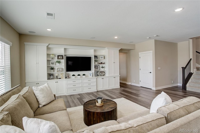 living area with stairway, wood finished floors, visible vents, and recessed lighting