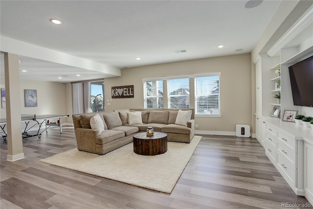 living room with baseboards, visible vents, wood finished floors, and recessed lighting