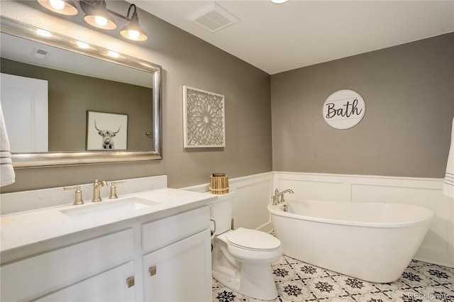 bathroom featuring wainscoting, visible vents, a freestanding bath, and vanity