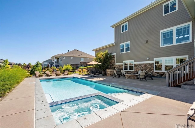 pool featuring an in ground hot tub and a patio