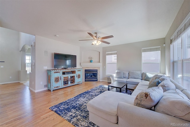 living area with light wood-type flooring, plenty of natural light, and a ceiling fan