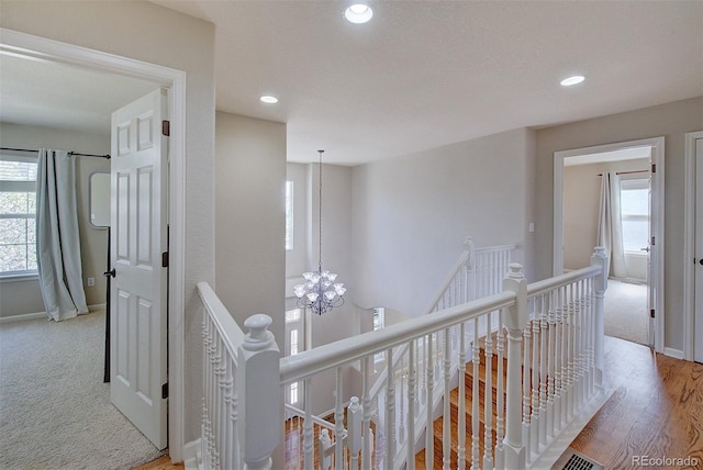 hall featuring recessed lighting, carpet flooring, baseboards, and an upstairs landing