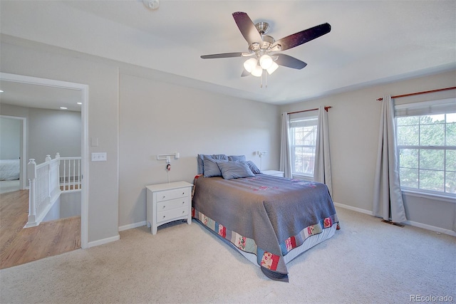 bedroom featuring a ceiling fan, baseboards, and light carpet