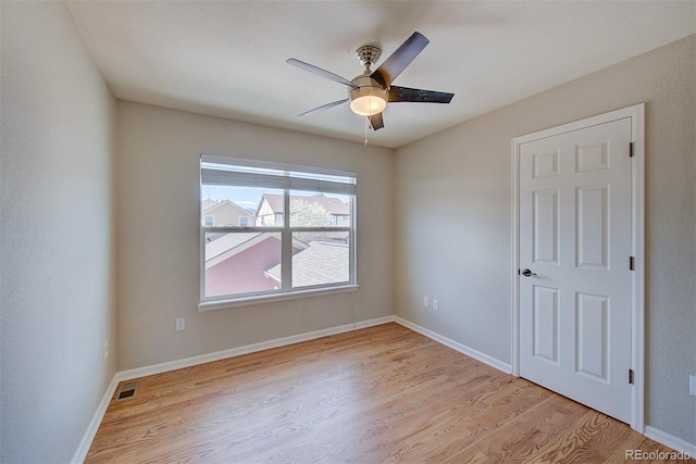 unfurnished room featuring a ceiling fan, baseboards, and light wood-style floors
