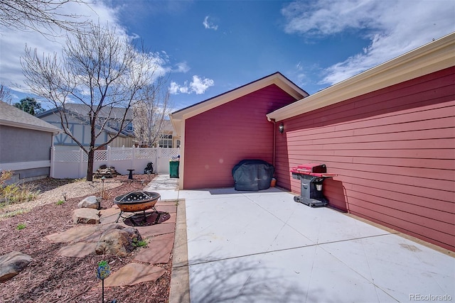 view of patio featuring fence and an outdoor fire pit