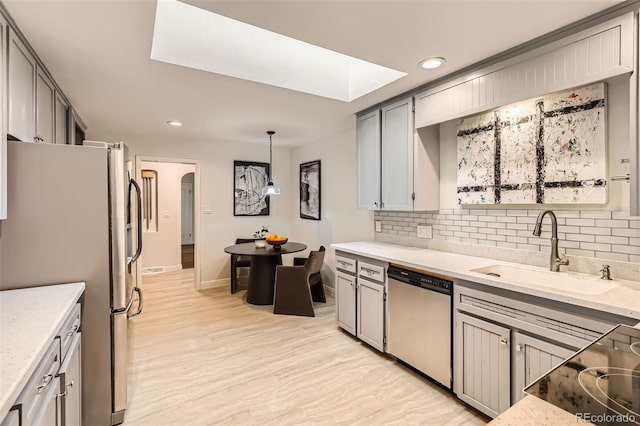 845 Everett St, Lakewood, CO 80215 - kitchen featuring appliances with stainless steel finishes, a sink, backsplash, recessed lighting, and light wood-style flooring
