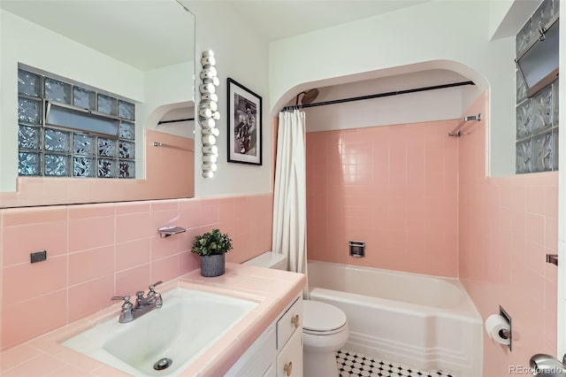 845 Everett St, Lakewood, CO 80215 - bathroom featuring tile walls, vanity, shower / bath combo with shower curtain, and toilet