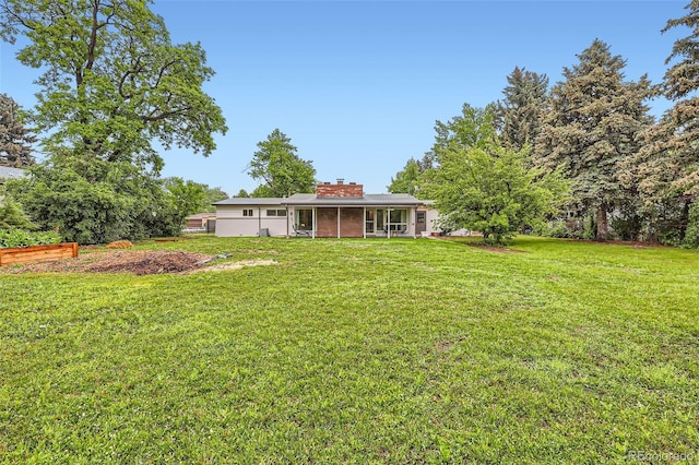 845 Everett St, Lakewood, CO 80215 - back of house featuring a lawn and a chimney