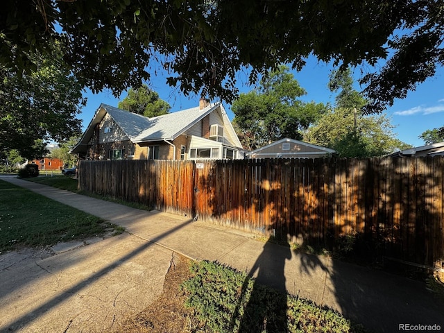 1731 E 25th Ave, Denver, CO 80205 - view of side of home with a fenced front yard and a chimney