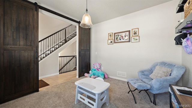 living area featuring light carpet and a barn door