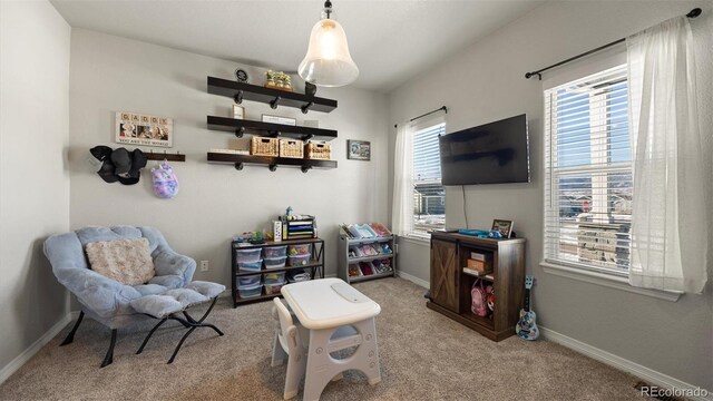 living area with a healthy amount of sunlight and light colored carpet