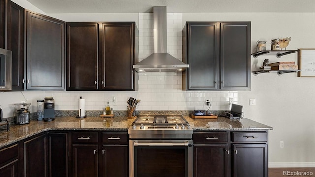 kitchen with gas range, dark brown cabinets, and wall chimney range hood