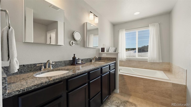 bathroom featuring vanity and tiled bath