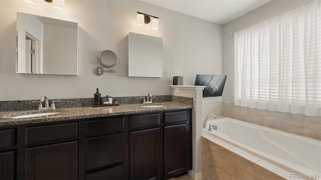 bathroom with vanity and tiled tub