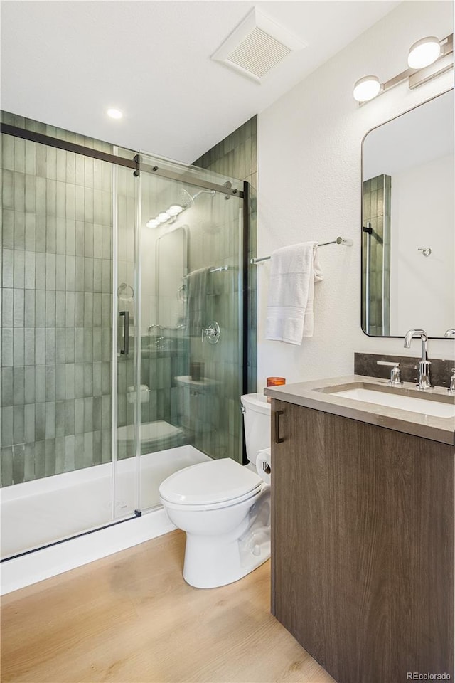 3295 Lawrence St, Denver, CO 80205 - bathroom with vanity, wood finished floors, and a stall shower
