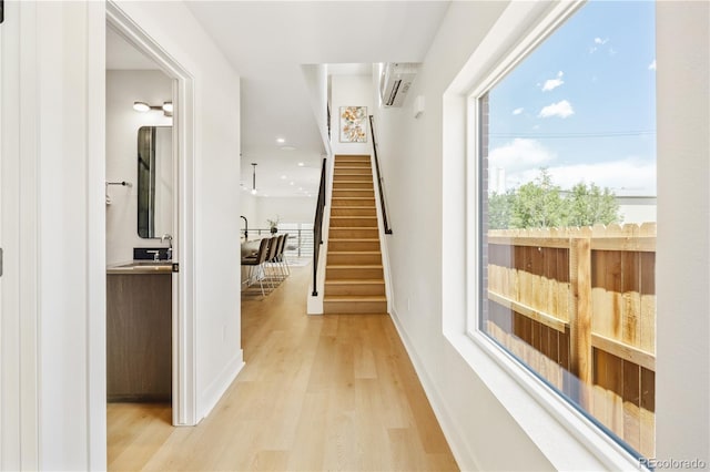3295 Lawrence St, Denver, CO 80205 - hallway featuring light wood-type flooring, stairs, a wall unit AC, and recessed lighting