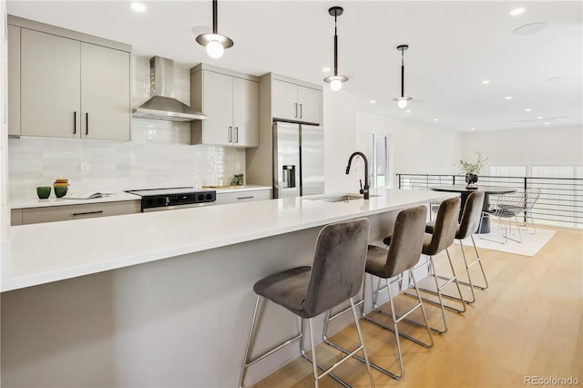 3295 Lawrence St, Denver, CO 80205 - kitchen with wall chimney exhaust hood, stainless steel fridge, stove, backsplash, and light wood-style flooring