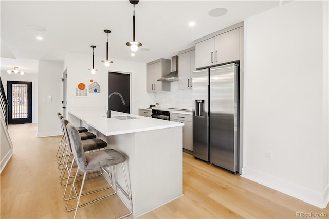3295 Lawrence St, Denver, CO 80205 - kitchen with stainless steel fridge with ice dispenser, wall chimney range hood, a breakfast bar, light wood-type flooring, and recessed lighting
