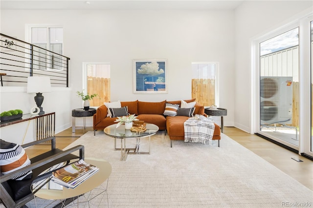 3295 Lawrence St, Denver, CO 80205 - living room featuring wood finished floors, a high ceiling, and stairs