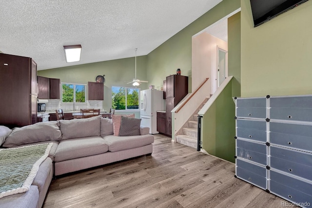 3730 Hazelwood Ct, Colorado Springs, CO 80918 - living area featuring light wood-style flooring, a textured ceiling, ceiling fan, stairs, and high vaulted ceiling